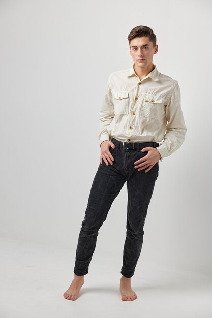 Portrait of young man standing against white background