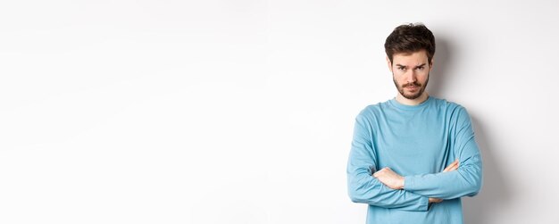 Photo portrait of young man standing against white background