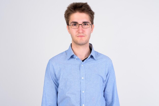 Portrait of young man standing against white background