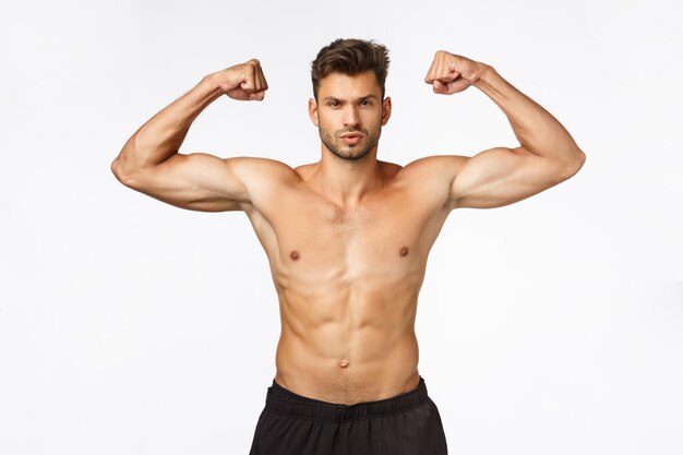 Portrait of young man standing against white background