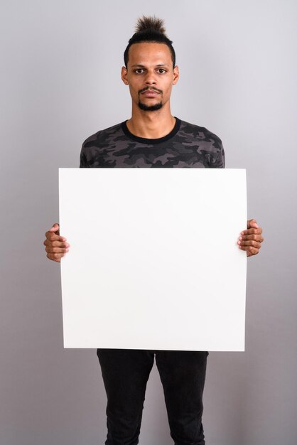 Portrait of young man standing against white background