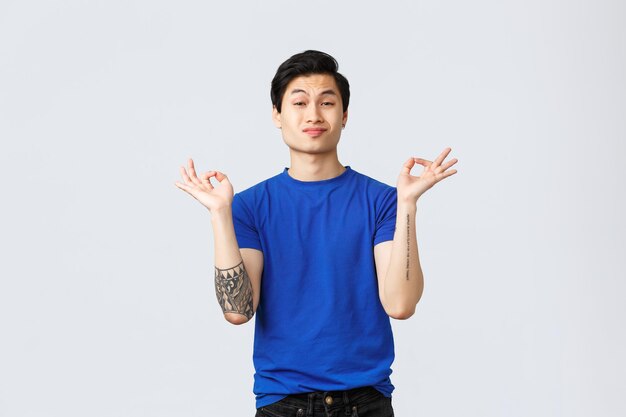 Portrait of young man standing against white background