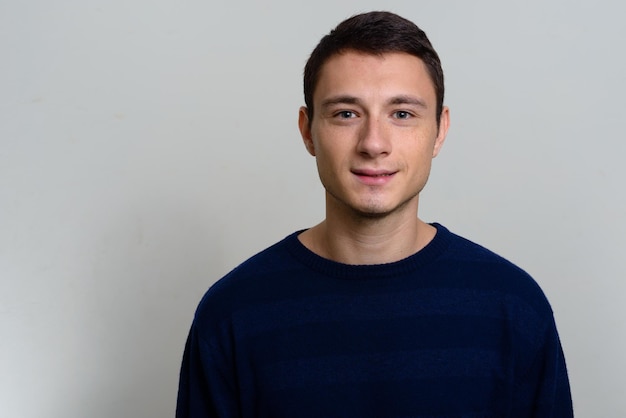 Portrait of young man standing against white background