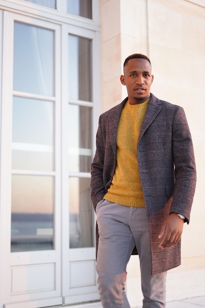 portrait of young man standing against window