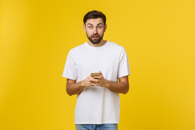 Portrait of young man standing against yellow background