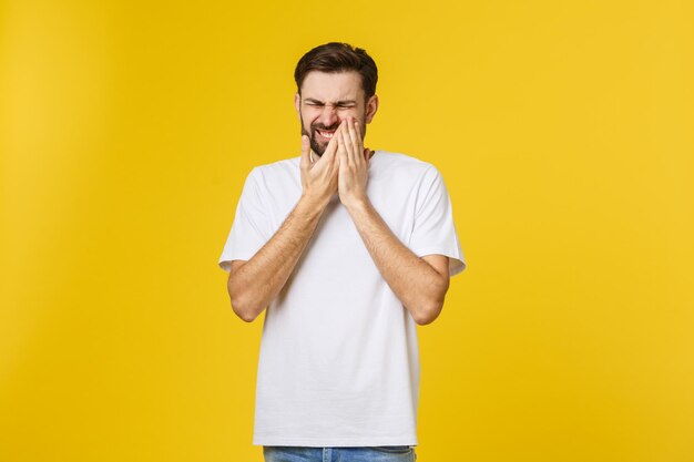 Portrait of young man standing against yellow background