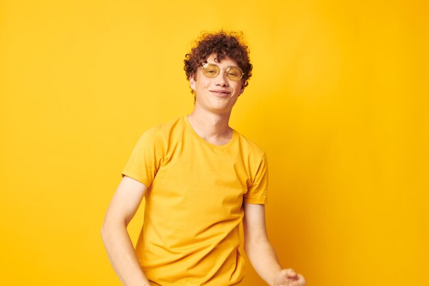 Portrait of young man standing against yellow background