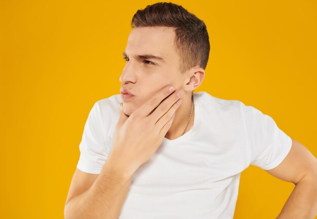 Portrait of young man standing against yellow background