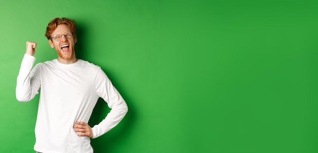 Portrait of young man standing against yellow background