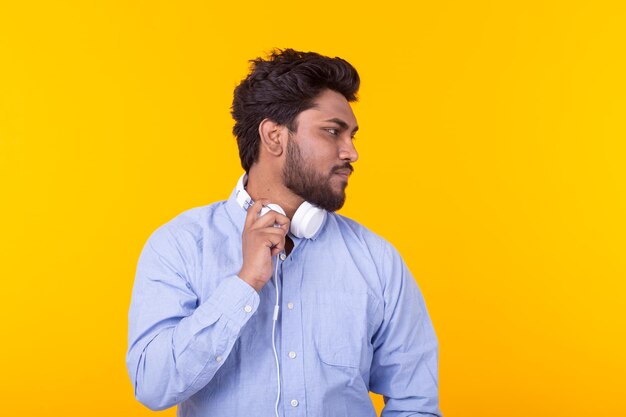 Portrait of young man standing against yellow background