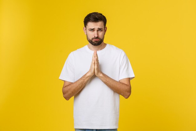 Portrait of young man standing against yellow background