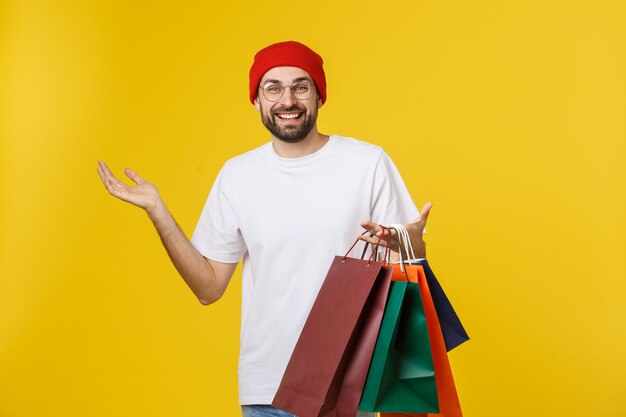 Portrait of young man standing against yellow background