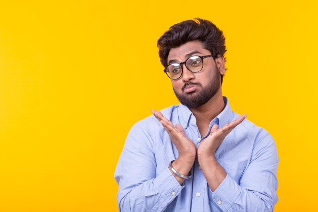 Portrait of young man standing against yellow background