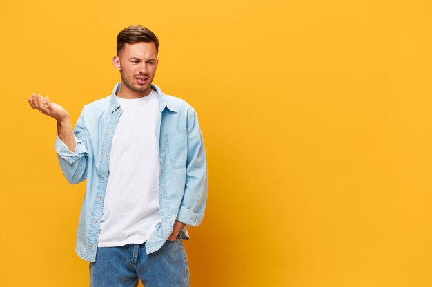 Portrait of young man standing against yellow background