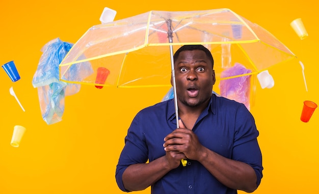 Portrait of young man standing against yellow background