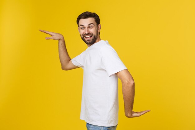 Portrait of young man standing against yellow background