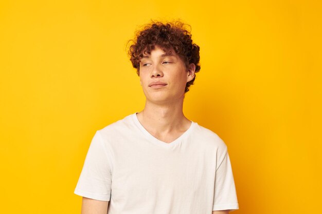 Portrait of young man standing against yellow wall