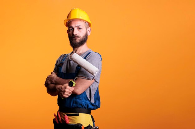 Portrait of young man standing against yellow wall