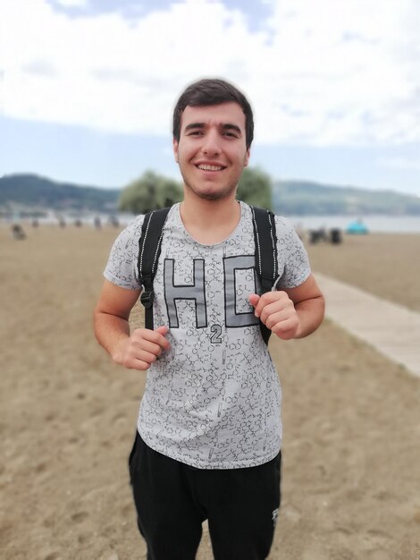 Photo portrait of young man standing at beach