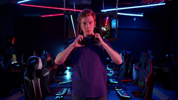 Portrait of young man standing in internet cafe