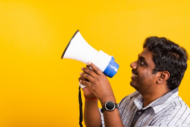 Portrait young man standing to make announcement message shouting screaming in megaphone