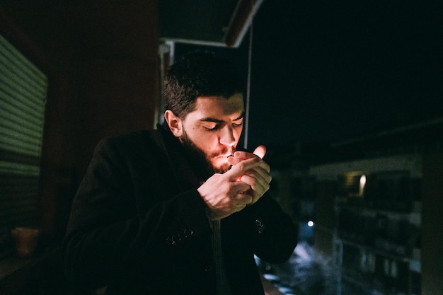 Photo portrait of young man standing at night