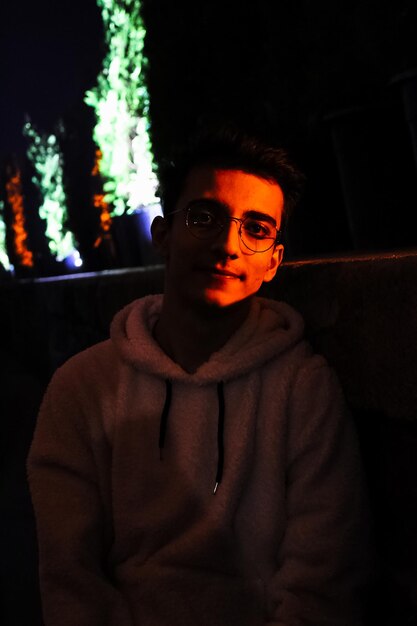Foto ritratto di un giovane in piedi di notte