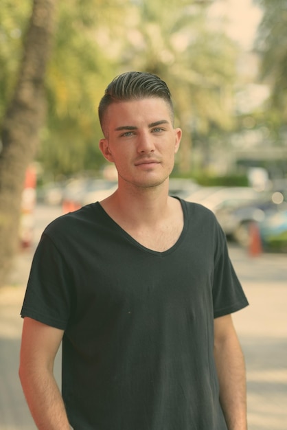 Photo portrait of young man standing outdoors