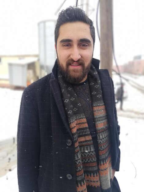 Photo portrait of young man standing on snow covered land