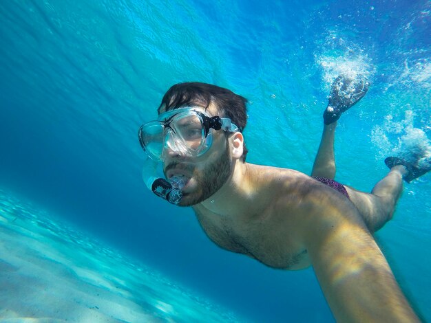 Portrait of young man swimming in sea