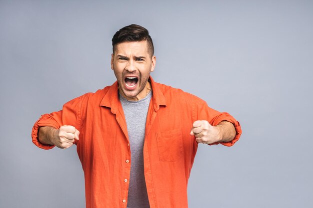 Portrait of young man unhappy angry mad aggressive quarrel\
problem scream isolated over white grey background