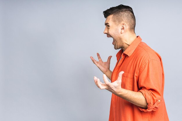 Portrait of young man unhappy angry mad aggressive quarrel\
problem scream isolated over white grey background