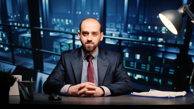 Portrait of young man using mobile phone while sitting in office