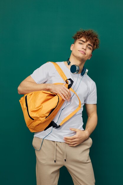 Portrait of young man using mobile phone while standing against blue background