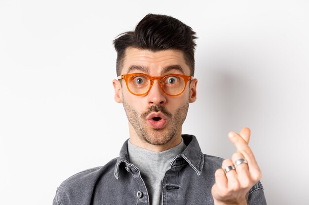 Portrait of young man wearing eyeglasses against white background