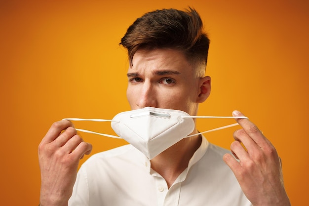 Portrait of a young man wearing face mask against yellow background