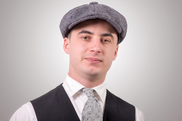 Photo portrait of young man wearing flat cap against gray background