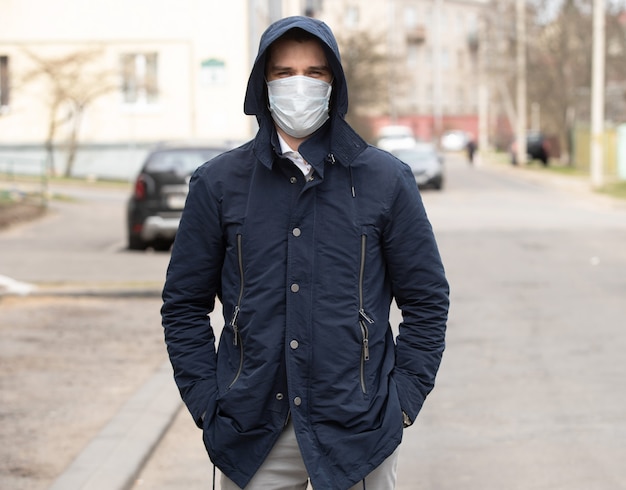 Ritratto di un giovane uomo che indossa la maschera protettiva sulla strada