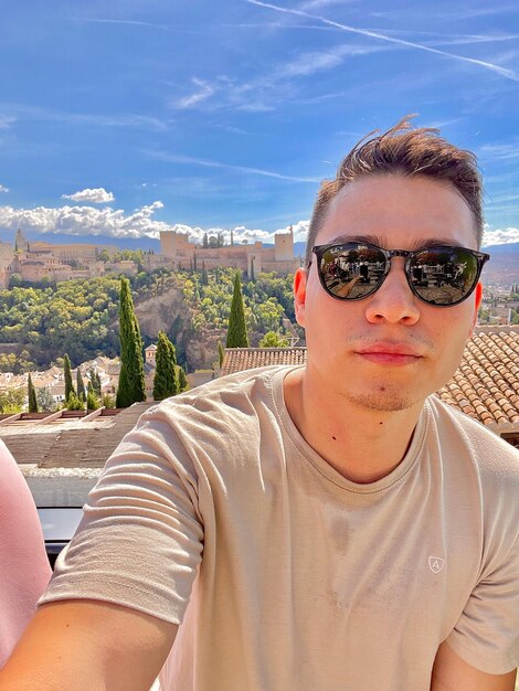 Portrait of young man wearing sunglasses against sky