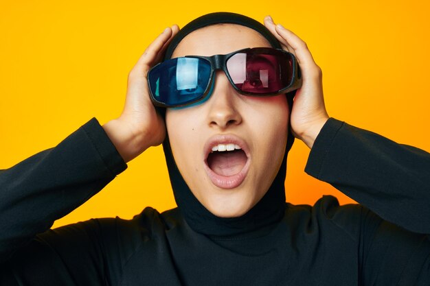 Portrait of young man wearing sunglasses against yellow background