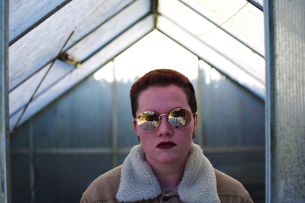 Photo portrait of young man wearing sunglasses in room