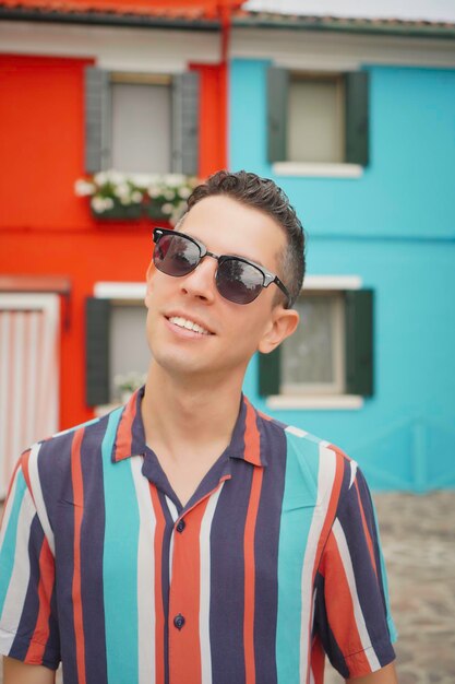 Photo portrait of young man wearing sunglasses standing outdoors