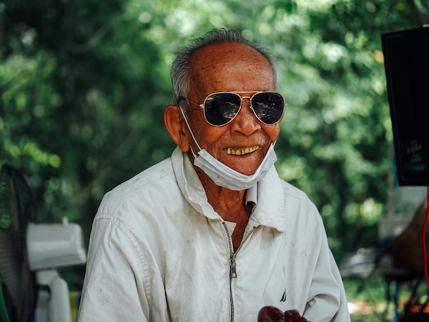 portrait of young man wearing sunglasses while standing against trees