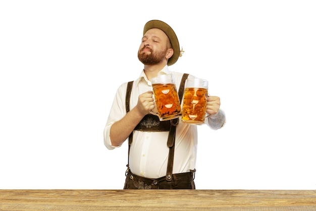 Portrait of young man wearing traditional bavarian or german clothes isolated over white background