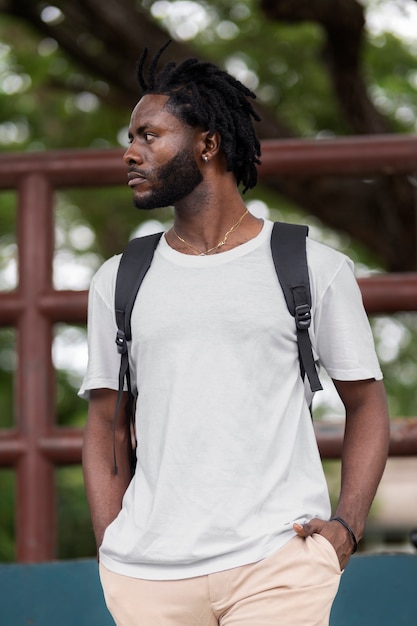 Portrait of young man with afro dreadlocks and backpack