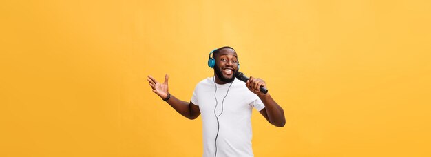 Portrait of young man with arms crossed against yellow background