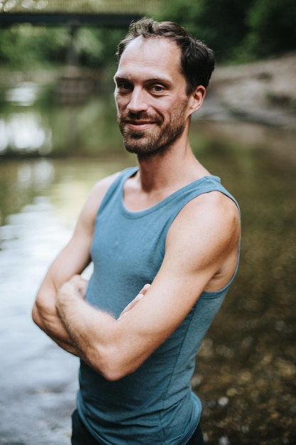 Photo portrait of young man with arms crossed standing in river