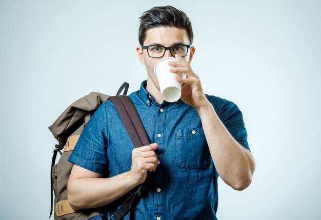 Portrait of young man with backpack isolated