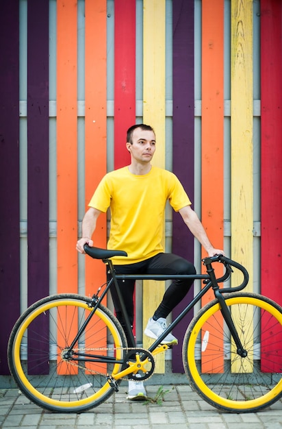 Foto ritratto di un giovane uomo con una bicicletta