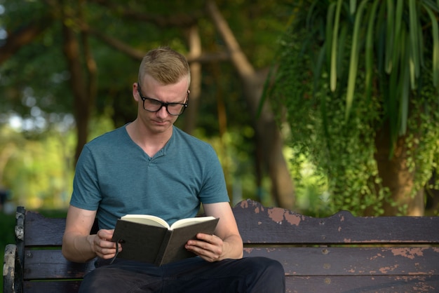 Portrait of young man with blond hair at the park outdoors